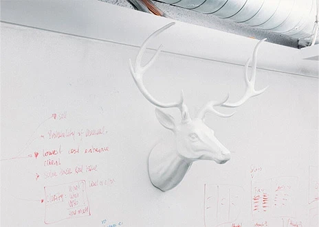 A white plastic stag head hangs on a whiteboard wall in a conference room at Adcetera’s Midtown office in Houston, Texas.