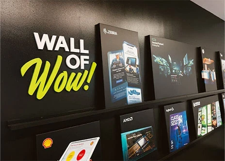 Work samples displayed on the wall of the conference room in Adcetera’s Midtown office in Houston, Texas. A sign on the wall reads, “Wall of Wow!”