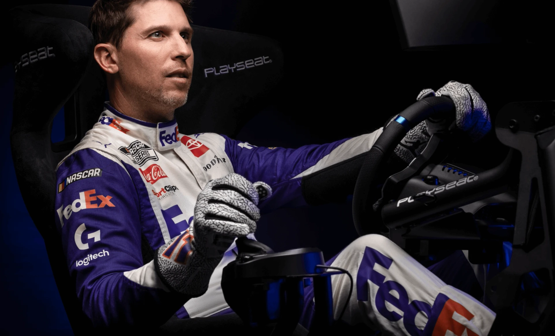 Professional stock car driver Denny Hamlin plays a racing simulation using a Playseat gaming chair and the Logitech G PRO Wheel and Pedals.