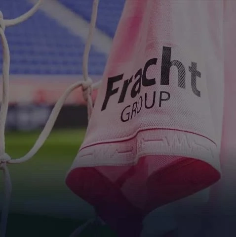 Close up view of an Inter Miami FC kit hanging on the goal netting with the Fracht Group logo shown prominently on the sleeve.