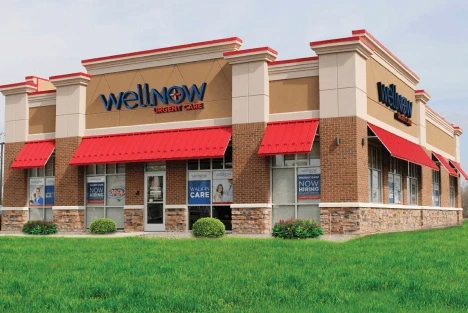 Exterior view of a WellNow Urgent Care center, with red awnings above the windows.