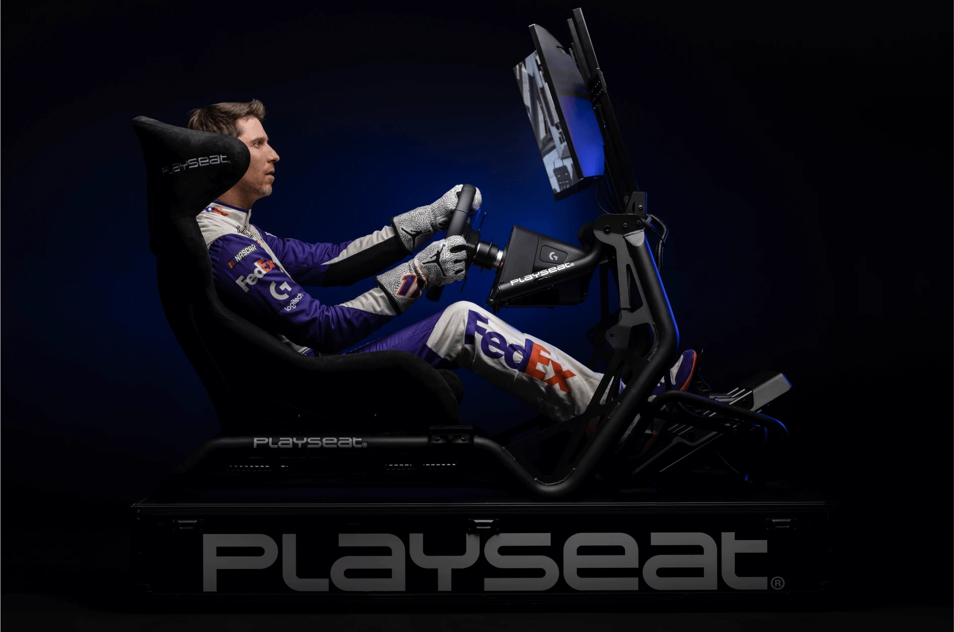Professional stock car driver Denny Hamlin plays a racing simulation using a Playseat gaming chair and the Logitech G PRO Wheel and Pedals.