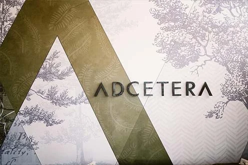 The “Adcetera” word mark is mounted on the wall of Adcetera’s office lobby in The Woodlands, Texas, with the company logo behind it.