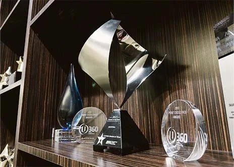 A selection of advertising awards are displayed on a wooden shelf in a conference room at Adcetera’s Midtown office in Houston, Texas.
